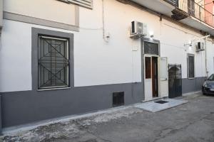 a white building with a window and a door at Big House near the Station in Torre Annunziata