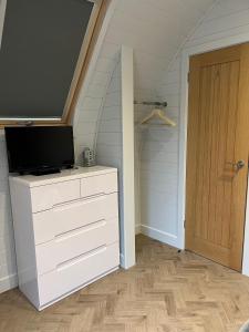 a room with a dresser with a television on top of it at The Pod @ Cold Comfort Farm in Hinckley