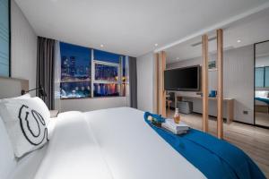 a bedroom with a large white bed and a television at Borrman Hotel - Guangzhou Beijing Road Pedestrian Street Donghu Subway Station in Guangzhou