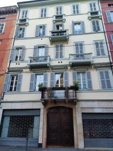 - un grand bâtiment blanc avec une porte et des fenêtres dans l'établissement Maison del Ducato Suite Parmigianino, à Parme
