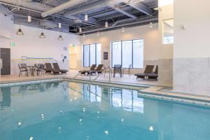 a swimming pool with chairs and tables in a building at DoubleTree by Hilton Calgary North in Calgary
