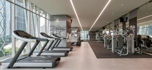 a gym with treadmills and ellipticals in a building at Alila SCBD Jakarta in Jakarta