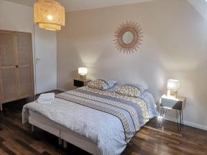 Schlafzimmer mit einem Bett und einem Wandspiegel in der Unterkunft La Bohème - Maison + Parking (Portes de Chartres) in Jouy