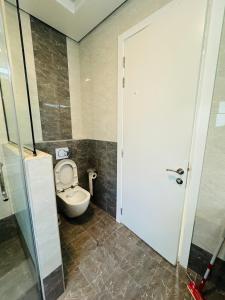 a bathroom with a toilet and a glass door at Centerpoint Duplex Villa in Dubai
