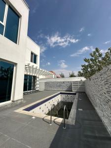 - un bâtiment avec une piscine à côté d'un mur de briques dans l'établissement Centerpoint Duplex Villa, à Dubaï