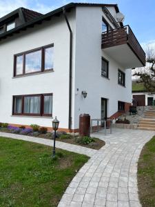 a white house with a brick driveway at Obstgarten am Bodensee in Bermatingen