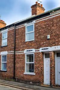 a red brick building with white windows and doors at Cosy 3-Bedroom Willow House in Selby