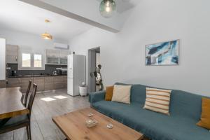 a living room with a blue couch and a table at Balliu Apartment in Triovasálos
