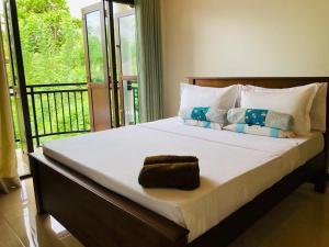 a bedroom with a large bed with a balcony at Sethumka Ayurveda & Yoga Resort in Wadduwa