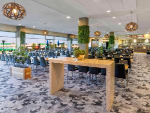 a dining room with a large table and chairs at Mantra Melbourne Melton in Melton