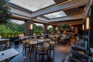 a restaurant with tables and chairs and large windows at Kwetu Nairobi, Curio Collection By Hilton in Nairobi