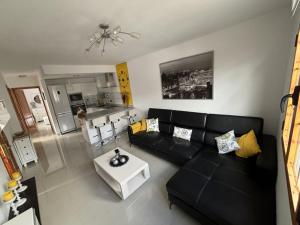 ein Wohnzimmer mit einer schwarzen Couch und einem Tisch in der Unterkunft El rincón de Cornelia en Tejeda in Tejeda + 11 Fotos