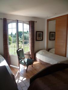 a bedroom with a bed and a chair and a window at Chambre d'hôtes "La Bastide des Eucalyptus" in Antibes