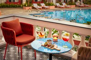 Ronil Goa - a JdV by Hyatt Hotel في كالانغيُت: طاولة عليها طعام بجانب مسبح