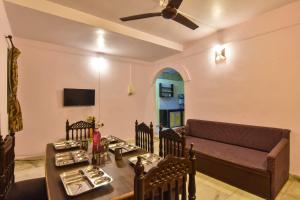 a dining room with a table and a couch at EMPYREAN STAY ll 2BHK II ROSE VILLA ll PVT POOL ll BBQ ll VIEW ll in Lonavala