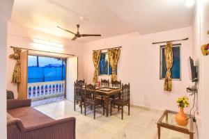 a living room with a table and chairs and a couch at EMPYREAN STAY ll 2BHK II ROSE VILLA ll PVT POOL ll BBQ ll VIEW ll in Lonavala