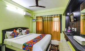 a bedroom with a large bed and a desk at Goroomgo Bollywood Sea View Room Puri in Puri