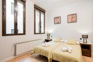 una camera da letto con due letti e due finestre di Atocha3 Superb Location - 4Bedrooms 2 Baths a Madrid