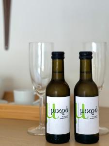 Voulis Best Global Home في أثينا: زجاجتان من البيرة تقعان على طاولة مع أكواب