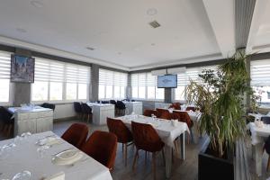 エディルネにあるCavit Duvan Prestige Hotelの白いテーブルと椅子、窓のあるレストラン