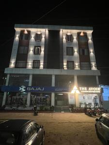 un edificio con un cartel en la parte delantera de la noche en Hotel The Avoir Asansol, en Āsansol