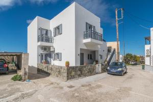 a white house with a car parked in front of it at Balliu Apartment in Triovasálos