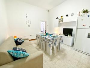 sala de estar con sofá, mesa y nevera en Aria di Mare - Elegante appartamento con patio, en Marina di Mancaversa