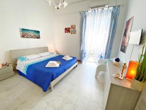 1 dormitorio con cama azul y escritorio en Aria di Mare - Elegante appartamento con patio, en Marina di Mancaversa