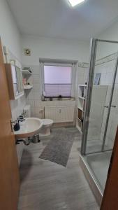 uma casa de banho com uma banheira, um lavatório e um chuveiro em Nordseebude em Husum