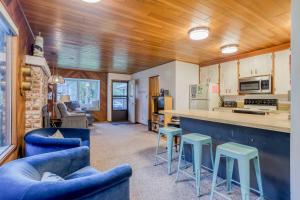 a kitchen and living room with blue chairs and a counter at Cabin on the Coast MCA 621 - Meredith Lodging in Manzanita