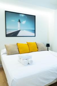 a living room with a white couch with a tv on the wall at BILBAO NORTH SHORE APARTMENTS 6 in Bilbao