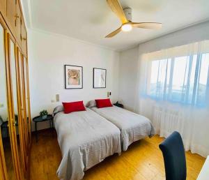 1 dormitorio con 1 cama con almohadas rojas y ventilador de techo en Chalet con piscina en altorreal, en La Alcayna