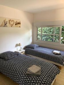 um quarto com 2 camas e uma janela em Villa piscine privée chauffée,vélos fournis, plage em Moliets-et-Maa