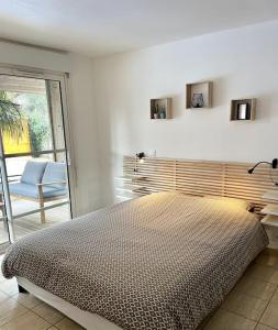 um quarto branco com uma cama e uma cadeira em Villa piscine privée chauffée,vélos fournis, plage em Moliets-et-Maa