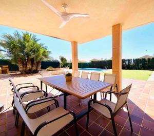 a table and chairs on a patio with a ceiling fan at Chalet con piscina en altorreal in La Alcayna