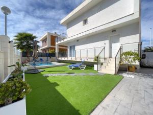 una casa con un patio con césped verde en Perfect Getaway Villa, en Gran Alacant