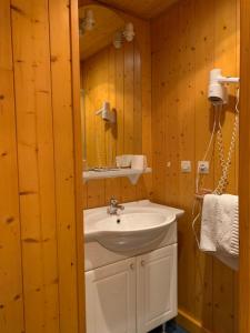 a bathroom with a white sink and a mirror at Hôtel La Vallée in Xonrupt-Longemer
