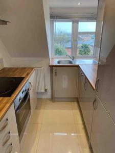 a small kitchen with a sink and a window at Luxury Penthouse Appartment in Cobham