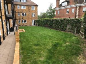 a yard with a lawn in front of a building at Luxury Penthouse Appartment in Cobham
