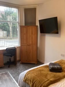 a bedroom with a bed and a flat screen tv at Coventry Train station studio in Coventry