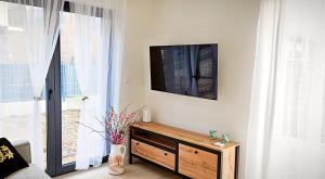 a living room with a flat screen tv on a wall at Apartamenty w Sercu Sosnówki in Sosnówka