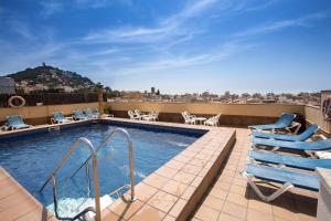 uma piscina no telhado de um edifício com espreguiçadeiras em Hotel Costa Brava em Blanes