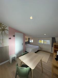 a bedroom with a bed and a table and chairs at Maison Meire Studios in Cognac