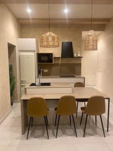 a kitchen with a table and chairs and a refrigerator at Emuna House A Coruña in A Coruña