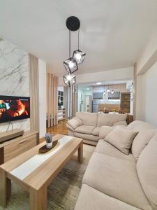 a living room with two white couches and a table at Lux Apartment Dolce Casa Skopje Karpos IV in Dolno Nerezi