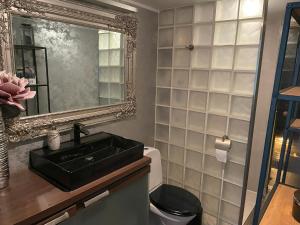 bagno con lavandino nero e specchio di Kunderi apartment with sauna a Rakvere