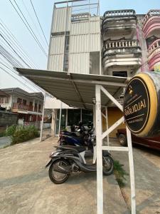 una motocicleta estacionada bajo un dosel frente a un edificio en Jidjai hostel en Chiang Rai