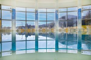 uma piscina com um reflexo na água em ANA Crowne Plaza Resort Appi Kogen, an IHG Hotel em Hachimantai