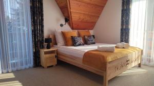 a bedroom with a large bed with a wooden headboard at Willa Adamówka in Zakopane