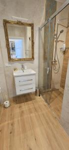 a bathroom with a sink and a mirror and a shower at Apartamenty w Sercu Sosnówki in Sosnówka +48 photos